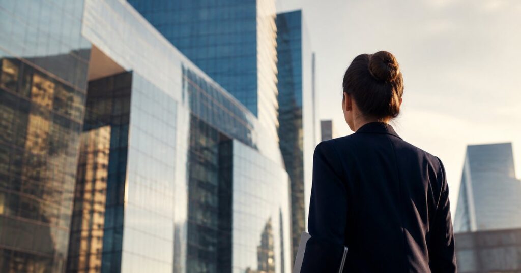 Jeune diplômée face aux tours de bureaux du quartier financier parisien