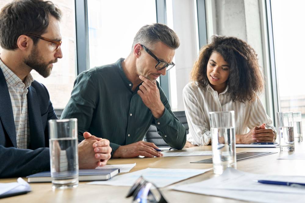 Réunion de travail autour de documents juridiques en entreprise